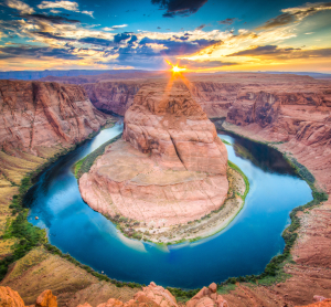 Hufeisenf&ouml;rmige Flussschleife zwischen roten Canyonw&auml;nden bei Sonnenuntergang.