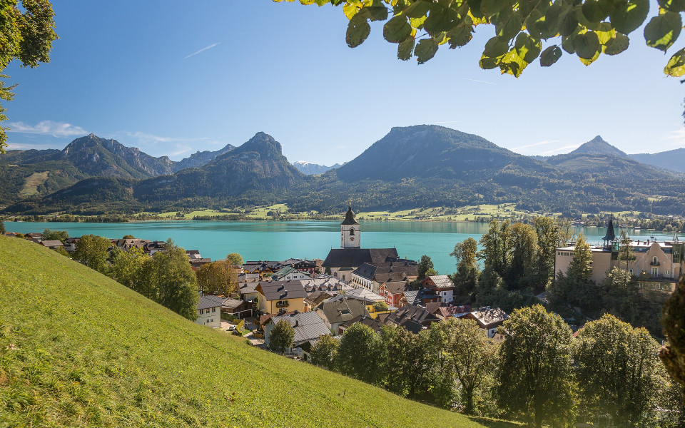 Blick auf St. Wolfgang und den Wolfgangsee im Salzburger Land mit Bergen im Hintergrund.
