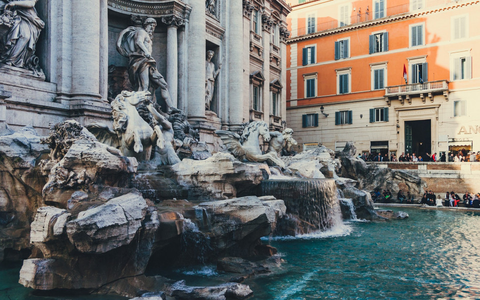 Majest&auml;tischer Trevi-Brunnen mit kunstvollen Skulpturen und t&uuml;rkisblauem Wasser, umgeben von historischen Geb&auml;uden.