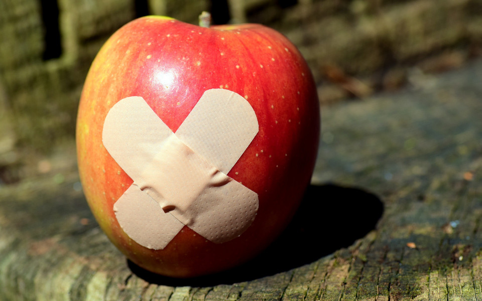 Roter Apfel mit Pflaster