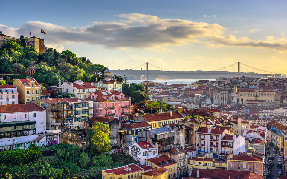 Blick auf das Stadtbild von Lissabon, mit dem Castelo de S&atilde;o Jorge im Hintergrund und der 25 de Abril Br&uuml;cke &uuml;ber dem Tejo-Fluss.