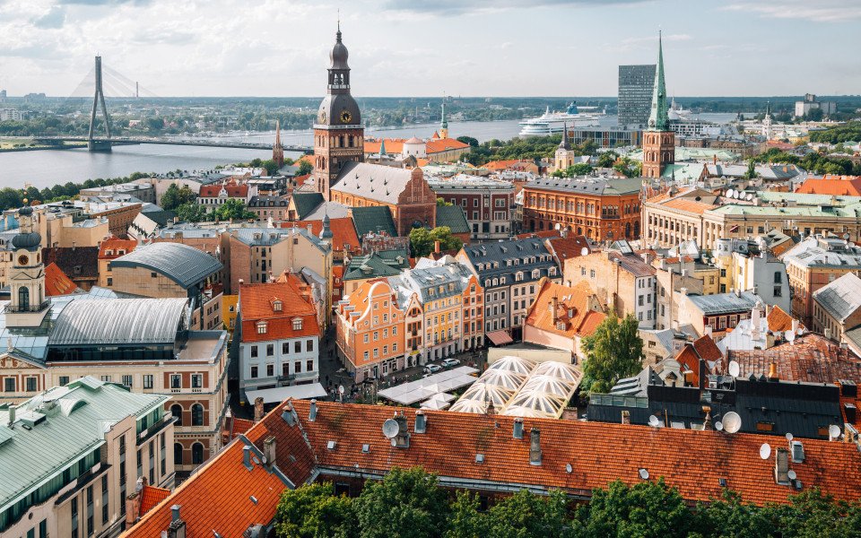 Blick auf die Altstadt von Riga mit ihren bunten D&auml;chern und dem Fluss Daugava im Hintergrund.